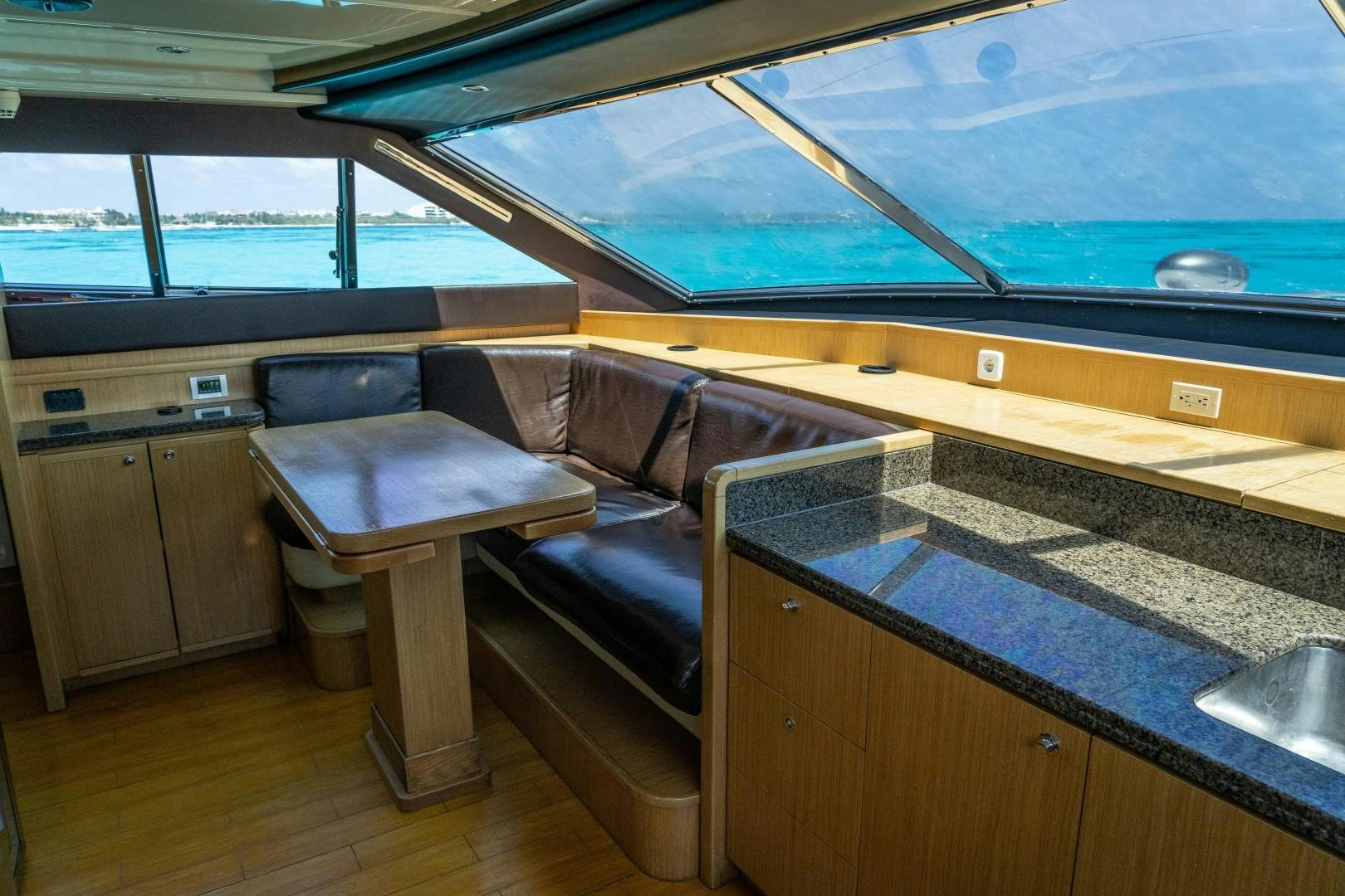 a couch and a table in a room with a window aboard FORTIS II Yacht for Sale