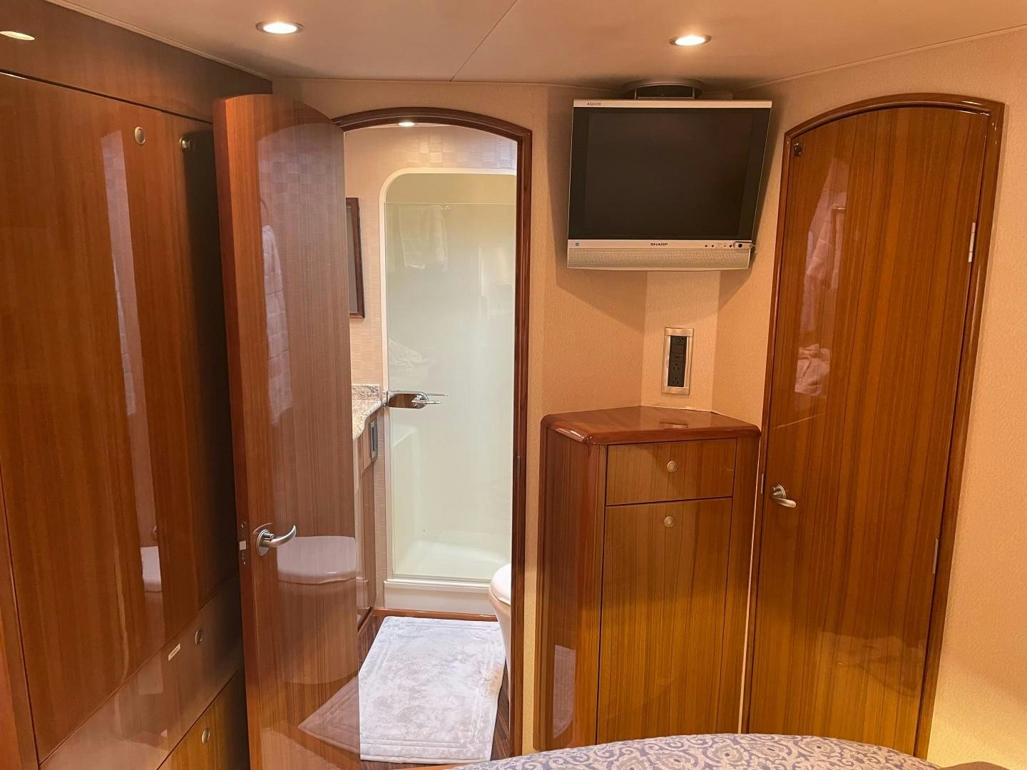 a bathroom with a tv and a standup shower aboard BANDIT Yacht for Sale