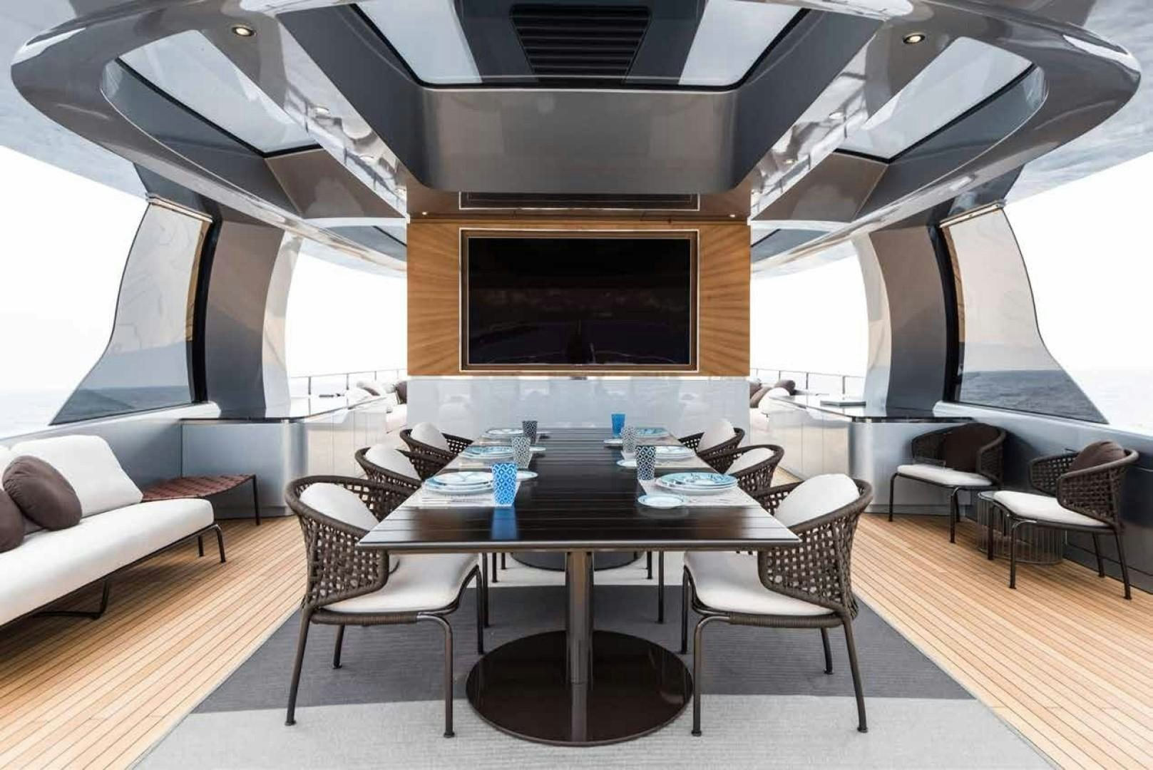 a room with a table and chairs aboard GTT 115 Yacht for Sale