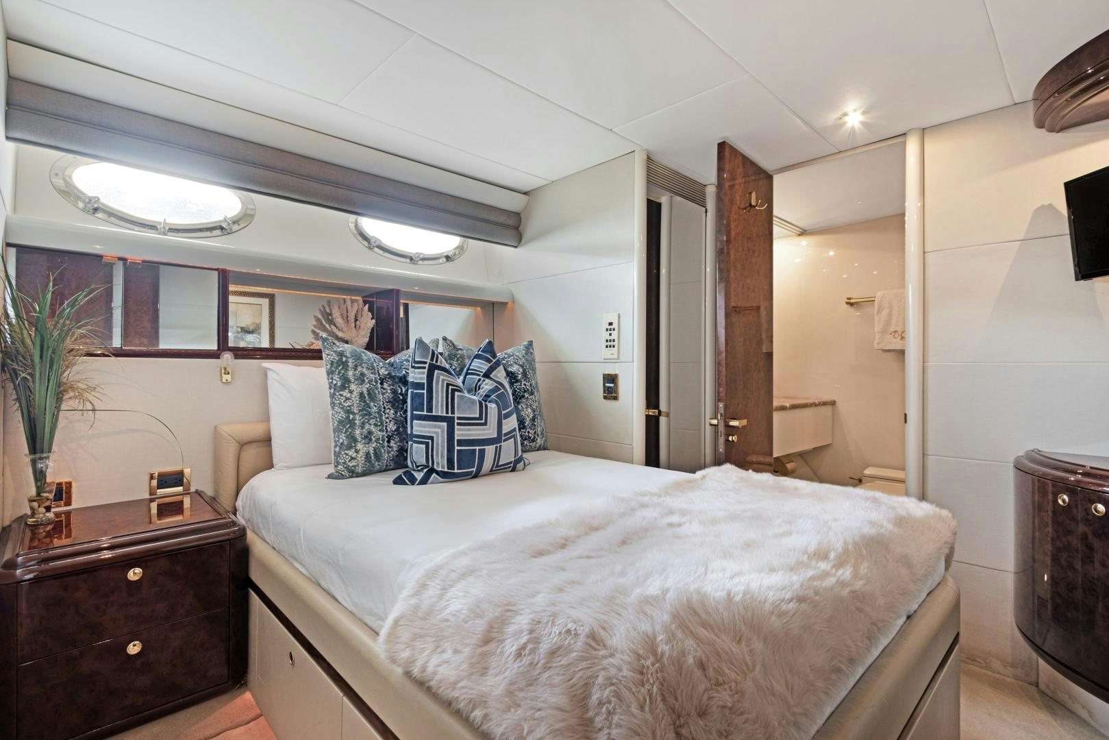 a bedroom with a bed and a dresser aboard BELLA GIORNATA Yacht for Sale