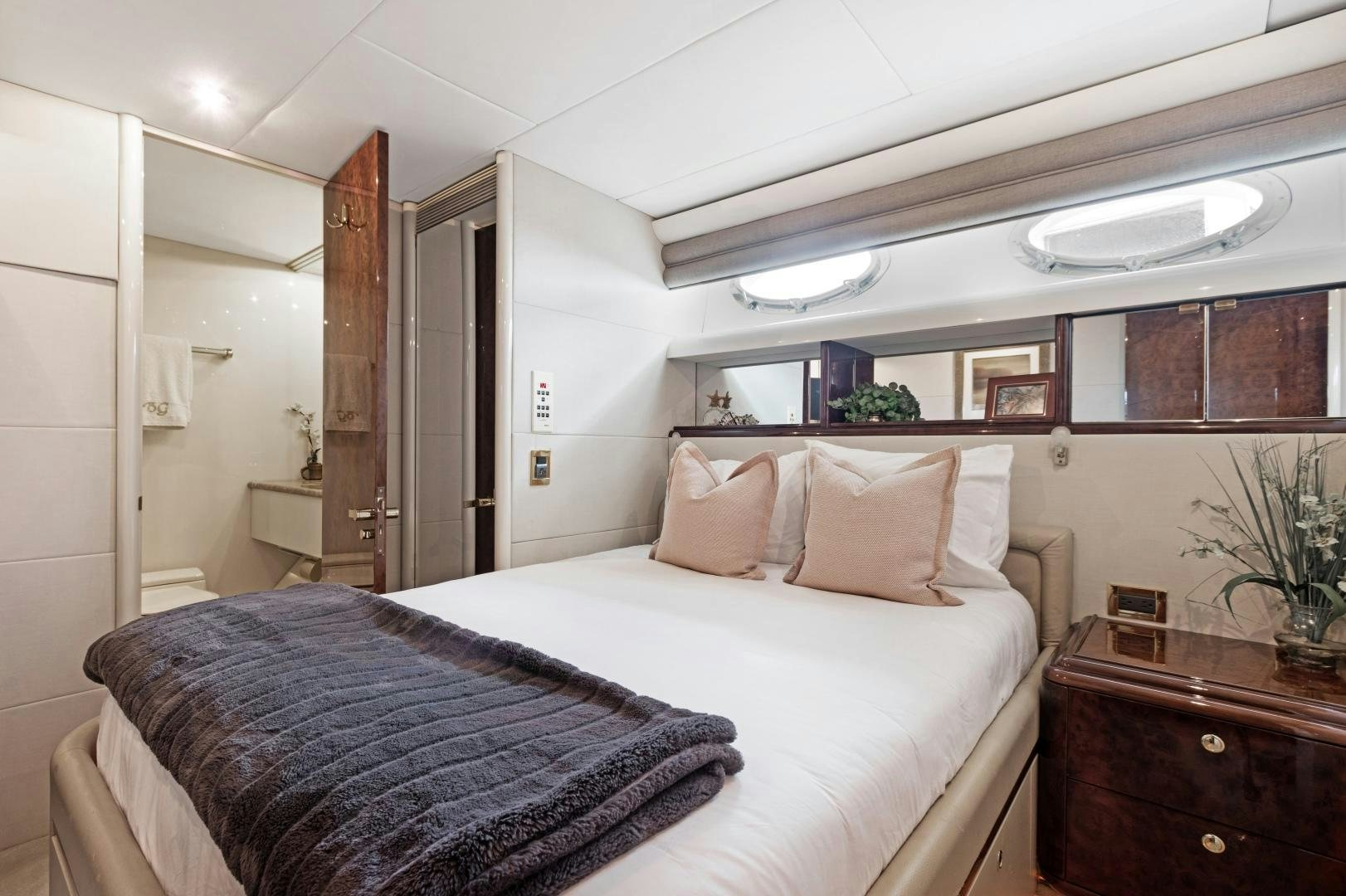 a bedroom with a bed and a dresser aboard BELLA GIORNATA Yacht for Sale
