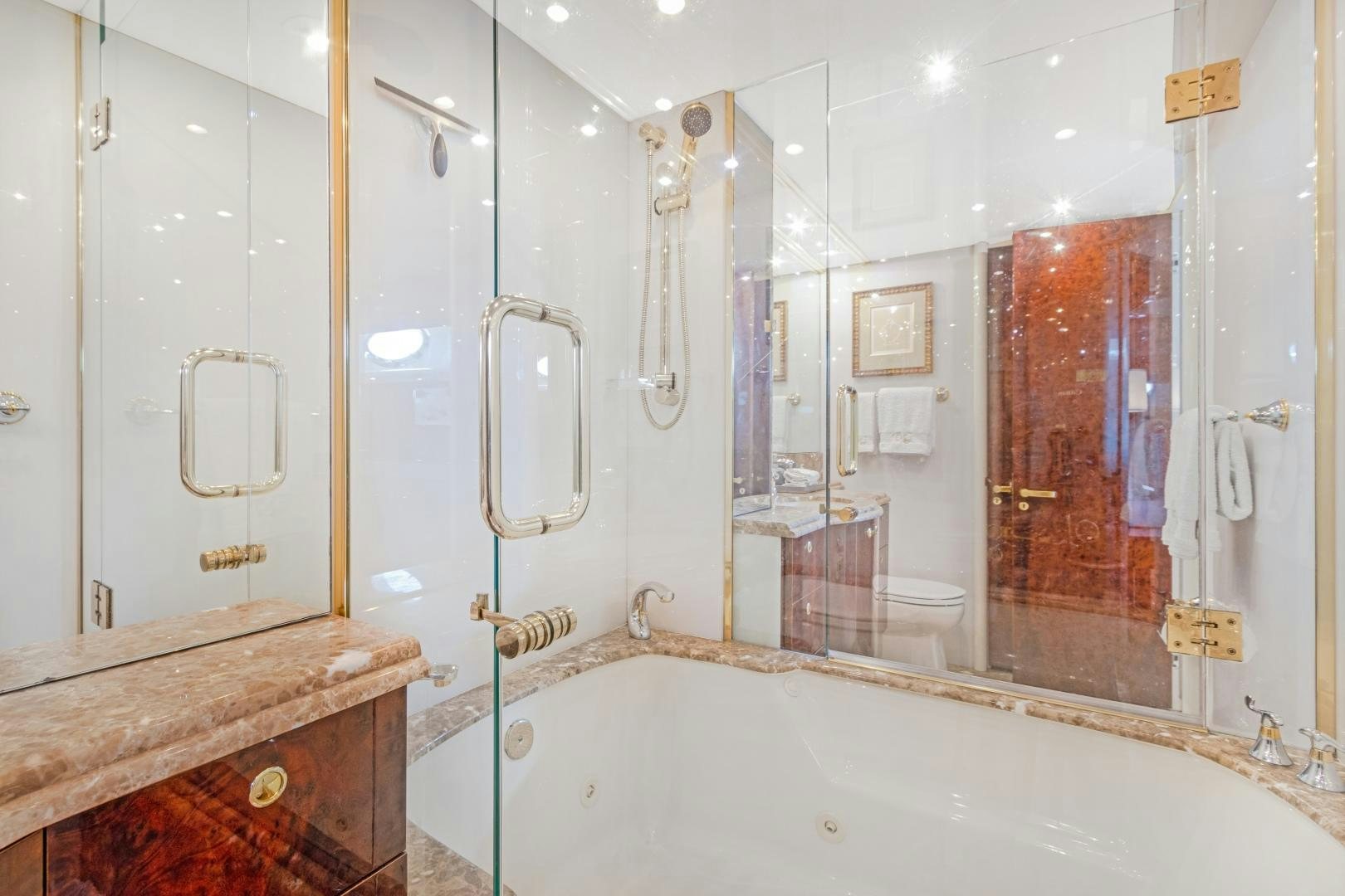 a bathroom with a bathtub and a mirror aboard BELLA GIORNATA Yacht for Sale