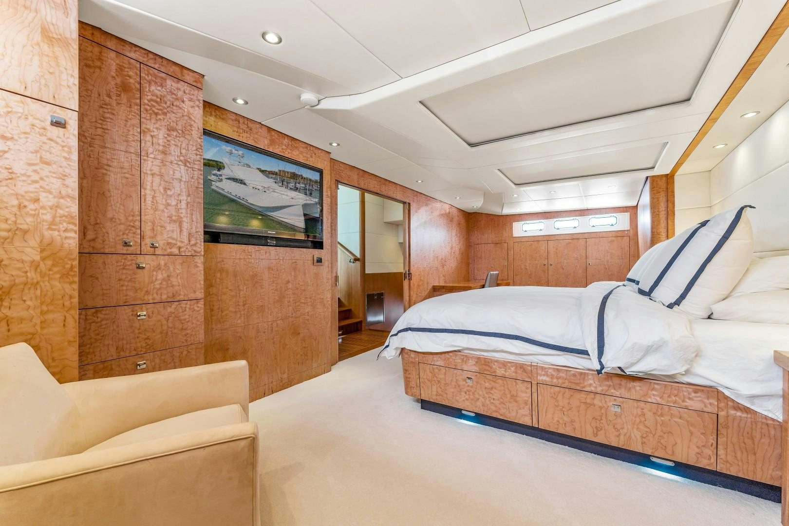 a bedroom with a bed and a wood cabinet aboard No Name Yacht for Sale
