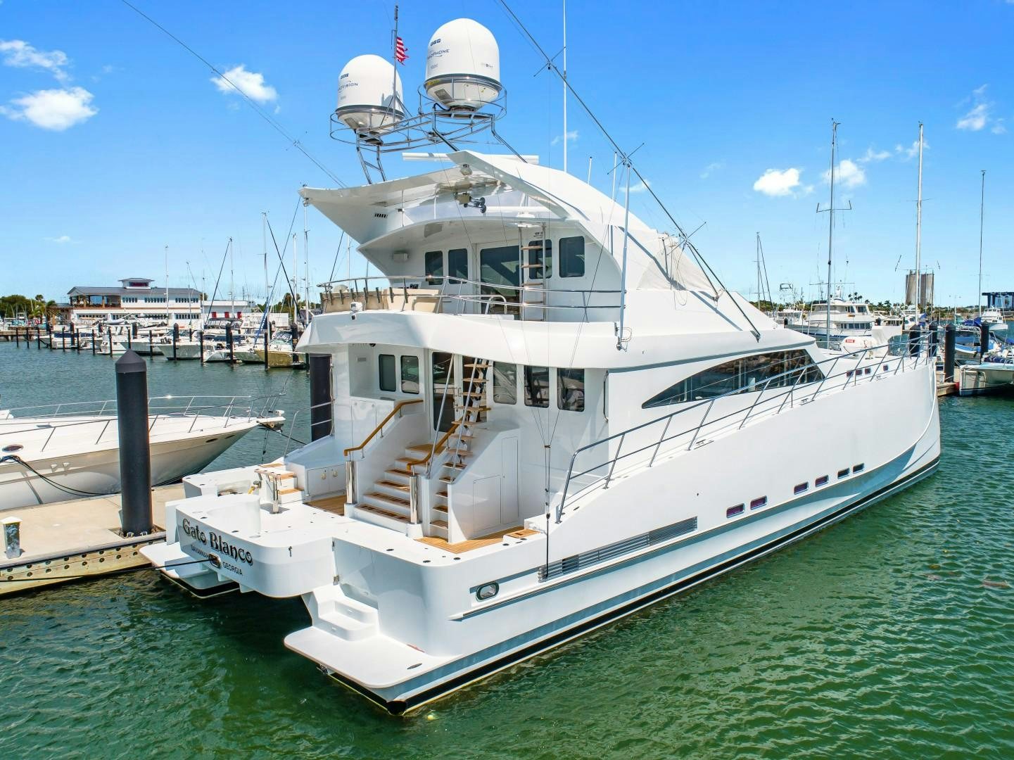 a large white boat docked at a pier aboard No Name Yacht for Sale