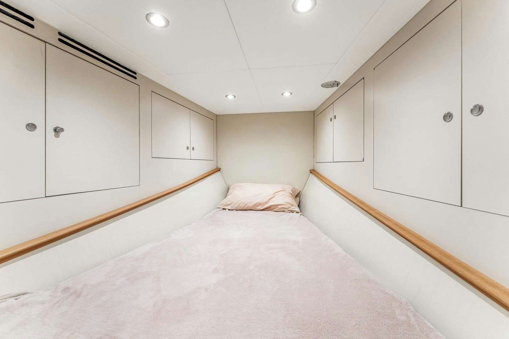 a bedroom with a bed and cabinets aboard No Name Yacht for Sale