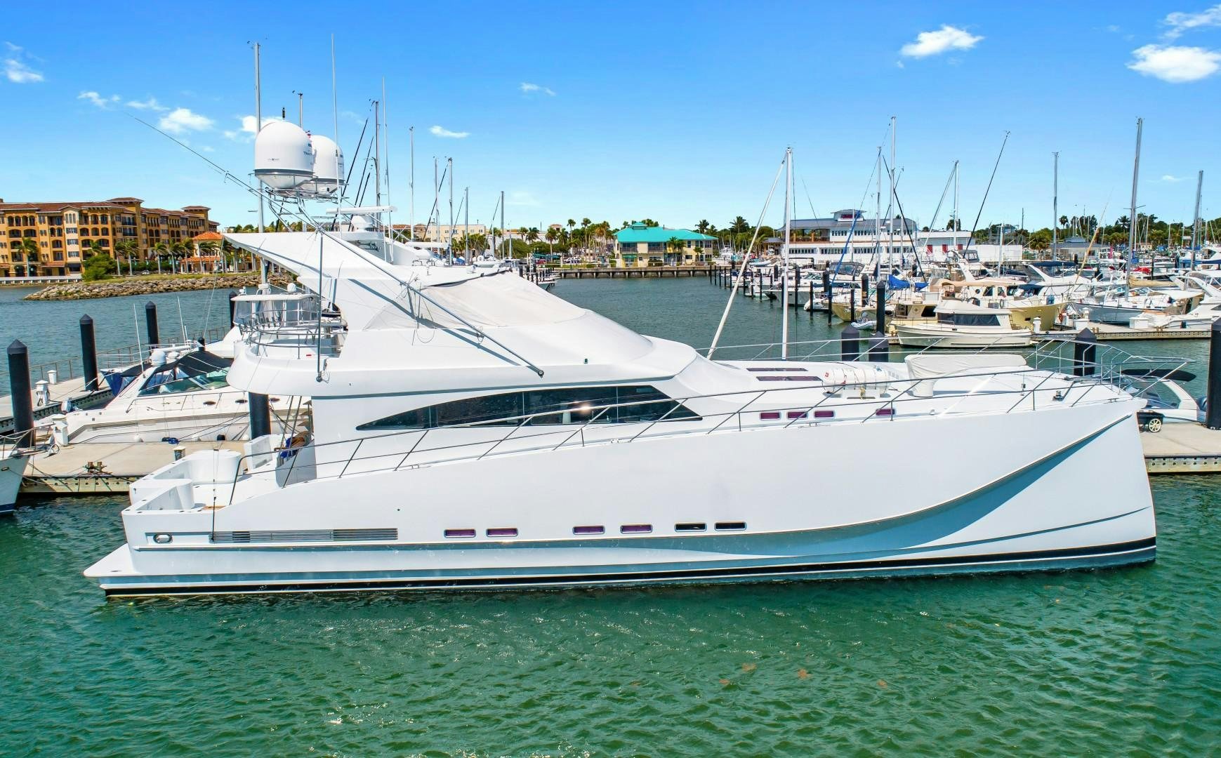 a large white yacht in a harbor aboard No Name Yacht for Sale