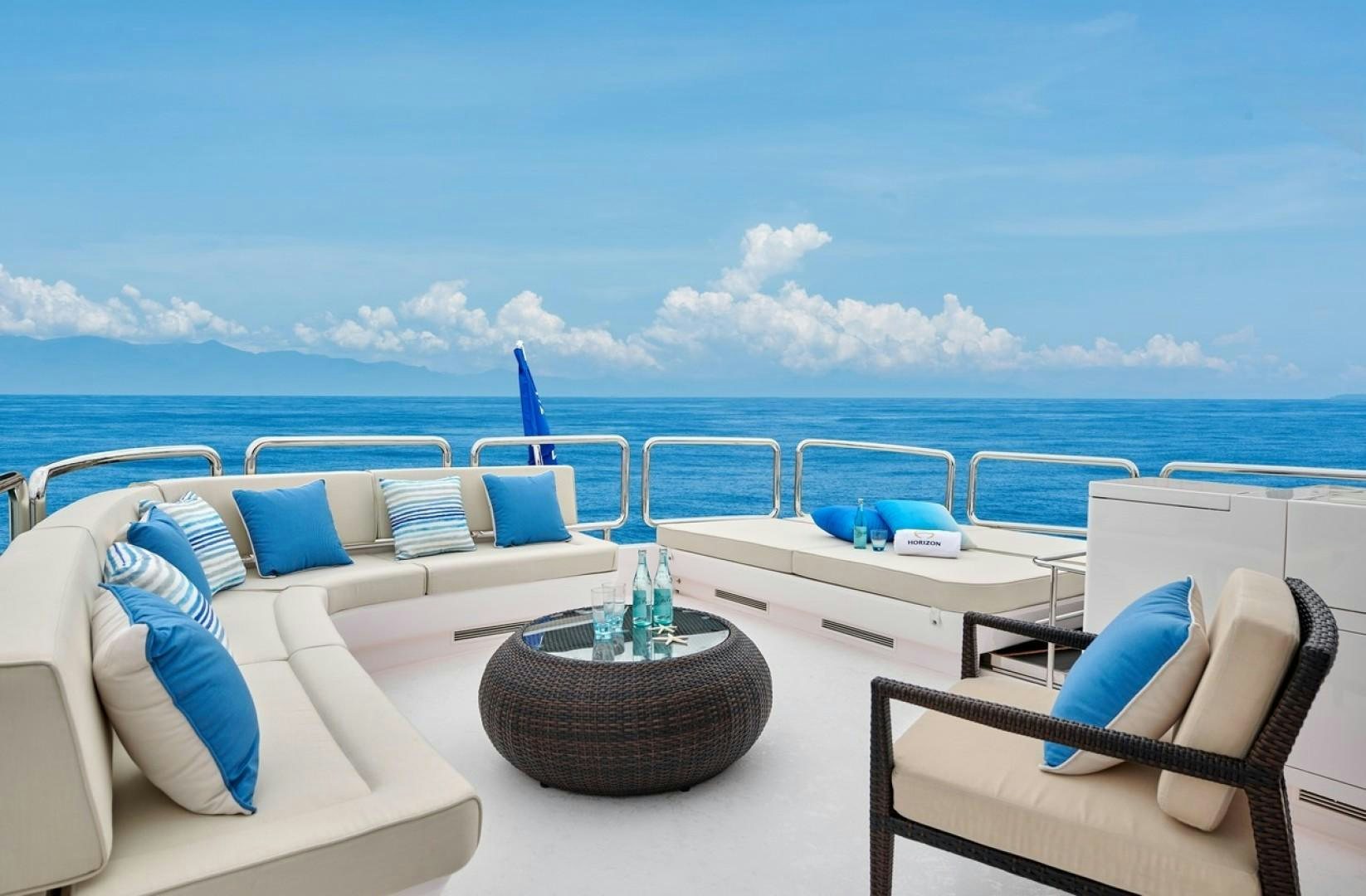 a room with a table chairs and a view of the ocean aboard E90 922 Yacht for Sale