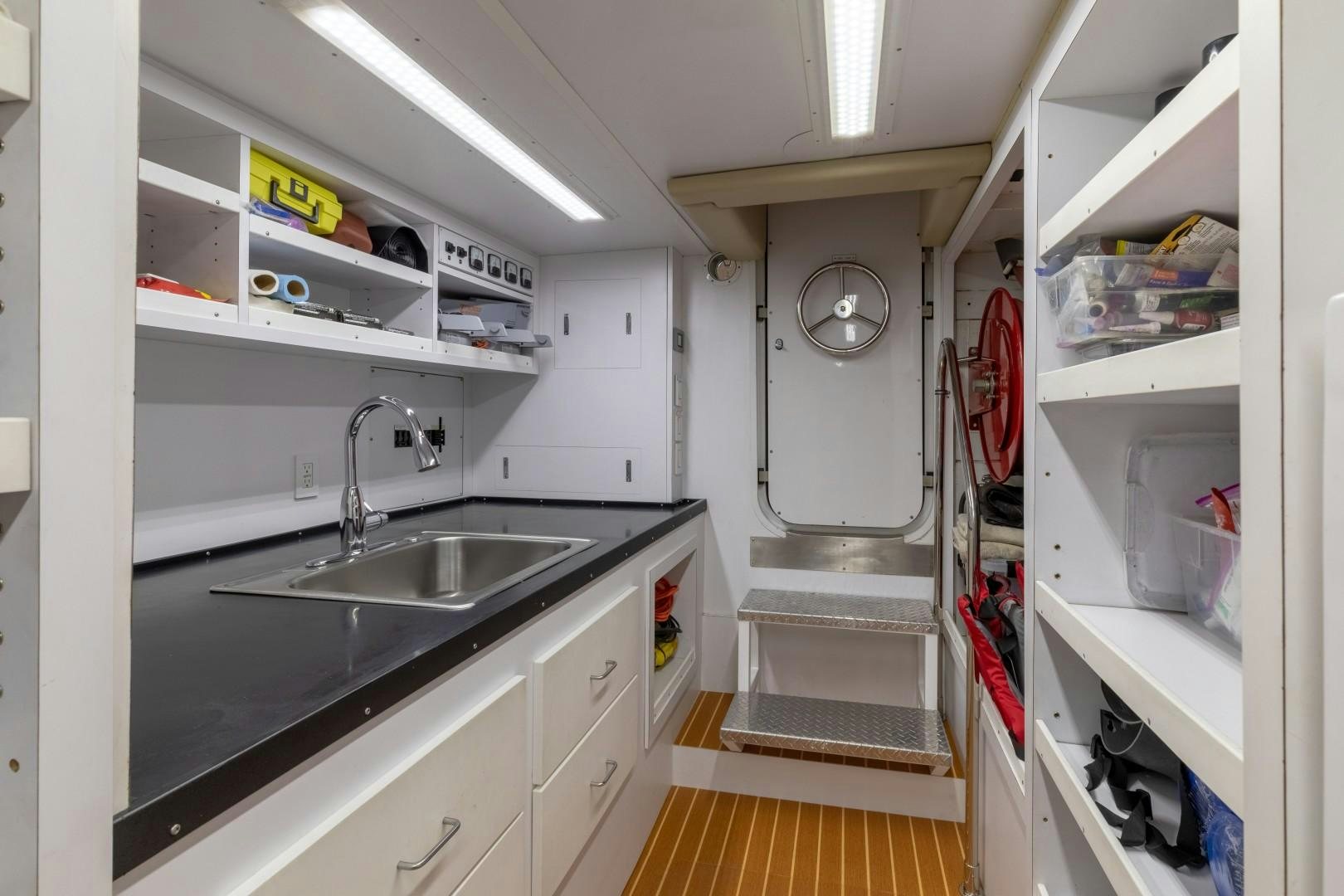 a kitchen with a sink and shelves aboard SINBAD Yacht for Sale