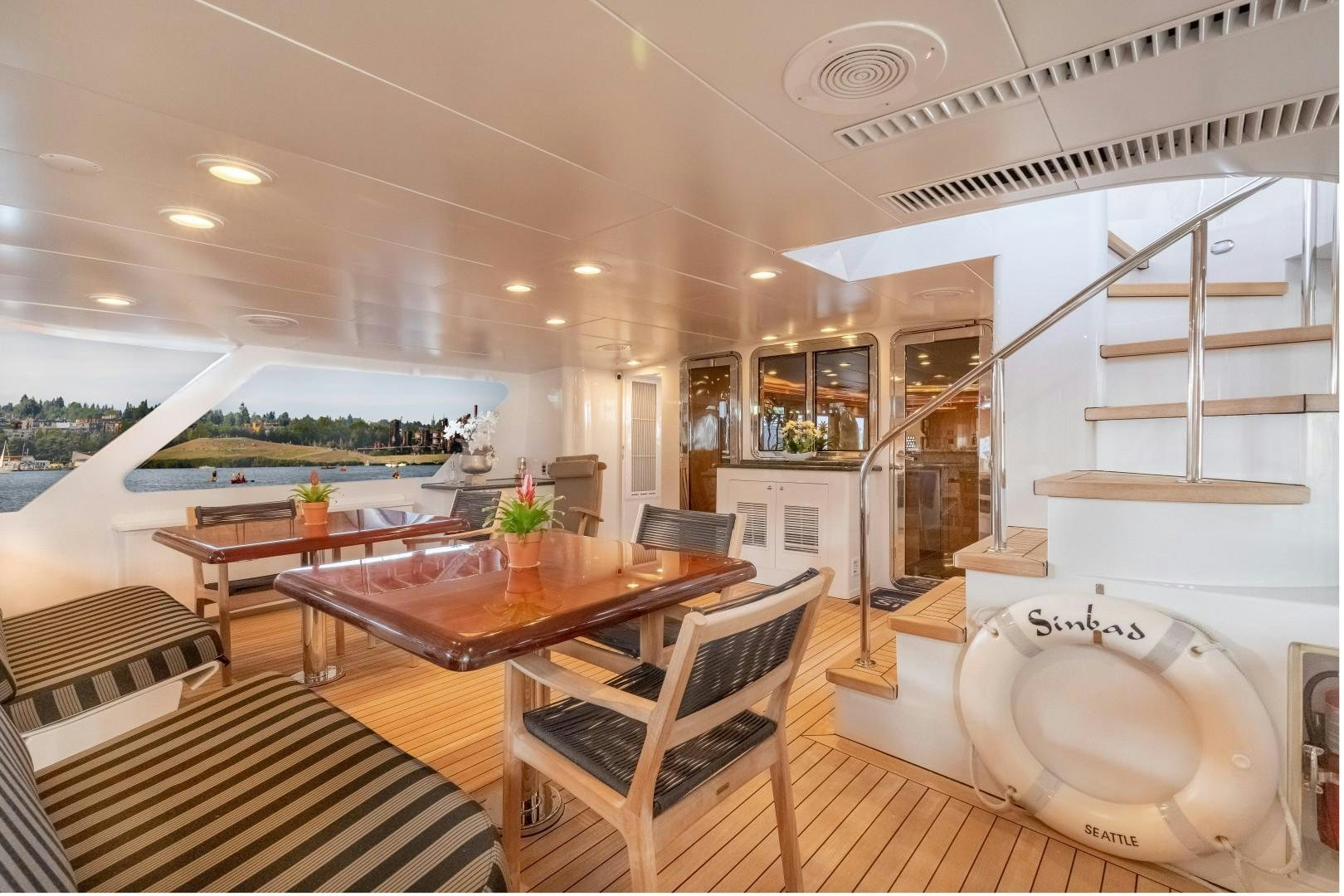 a modern looking kitchen with a dining table and chairs aboard SINBAD Yacht for Sale