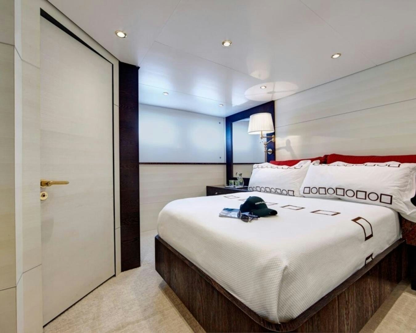 a bedroom with a bed and a lamp aboard HIGHLANDER Yacht for Sale