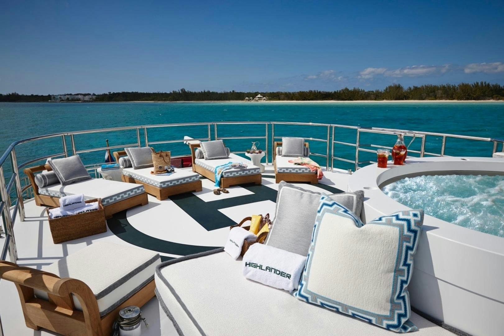 a pool with lounge chairs and a deck overlooking a beach aboard HIGHLANDER Yacht for Sale