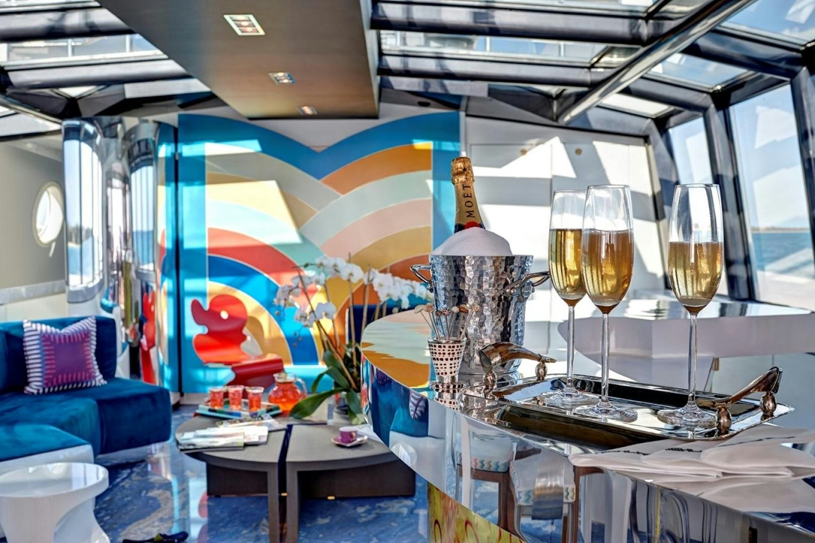 a room with a glass of champagne and a table with glasses aboard HIGHLANDER Yacht for Sale