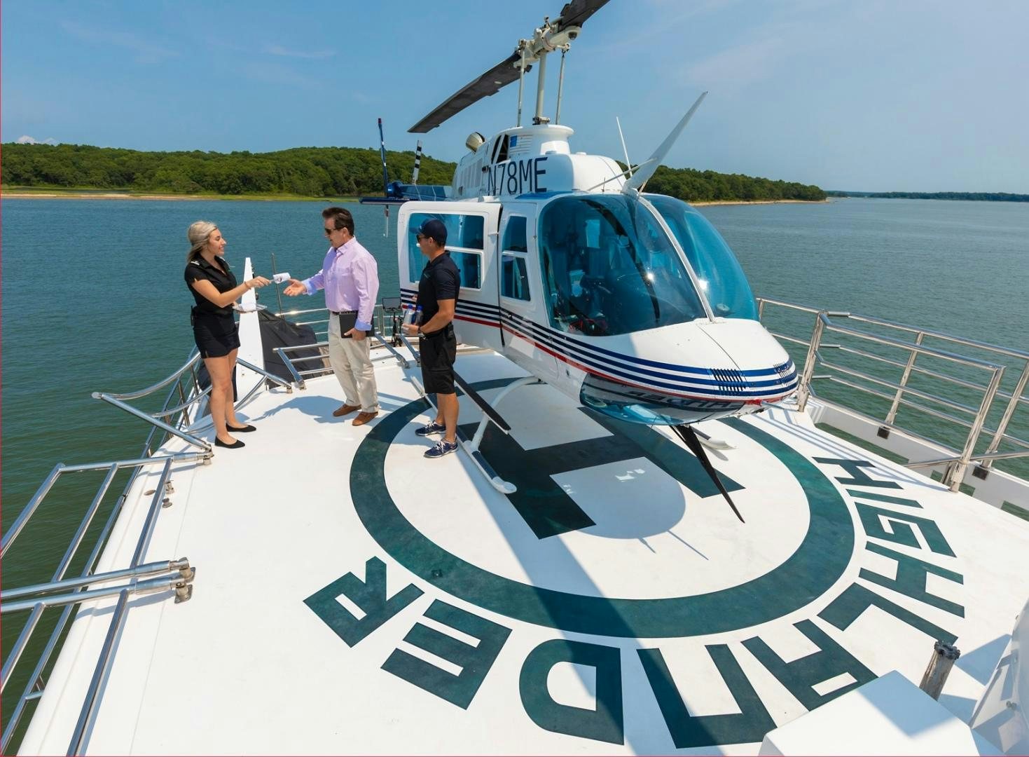 a group of people standing on a boat in the water aboard HIGHLANDER Yacht for Sale