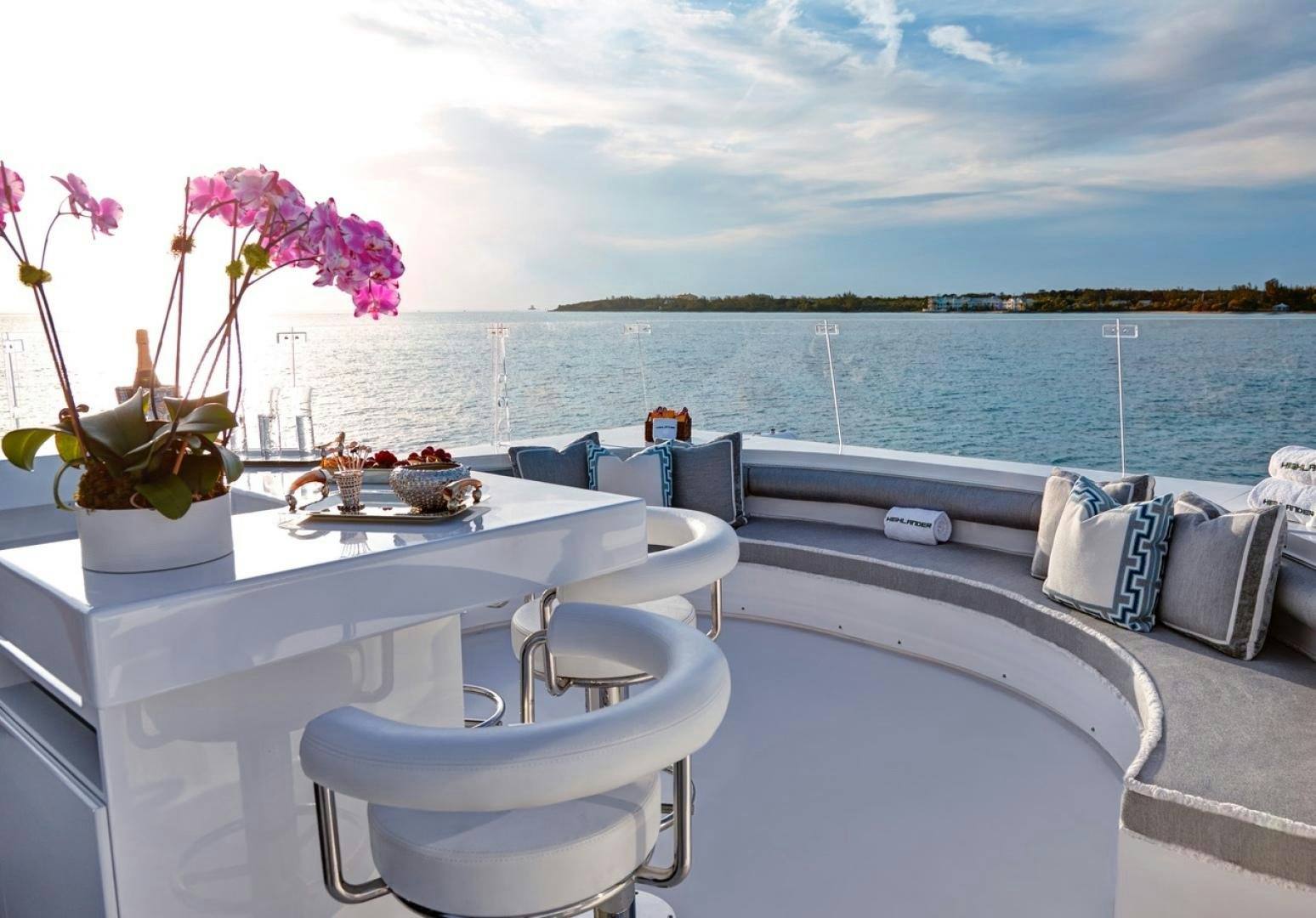 a white tub with flowers on it by a window with a view of water and land in the aboard HIGHLANDER Yacht for Sale