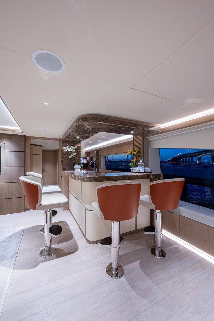 a room with a table chairs and a counter with a window aboard LIRA Yacht for Sale