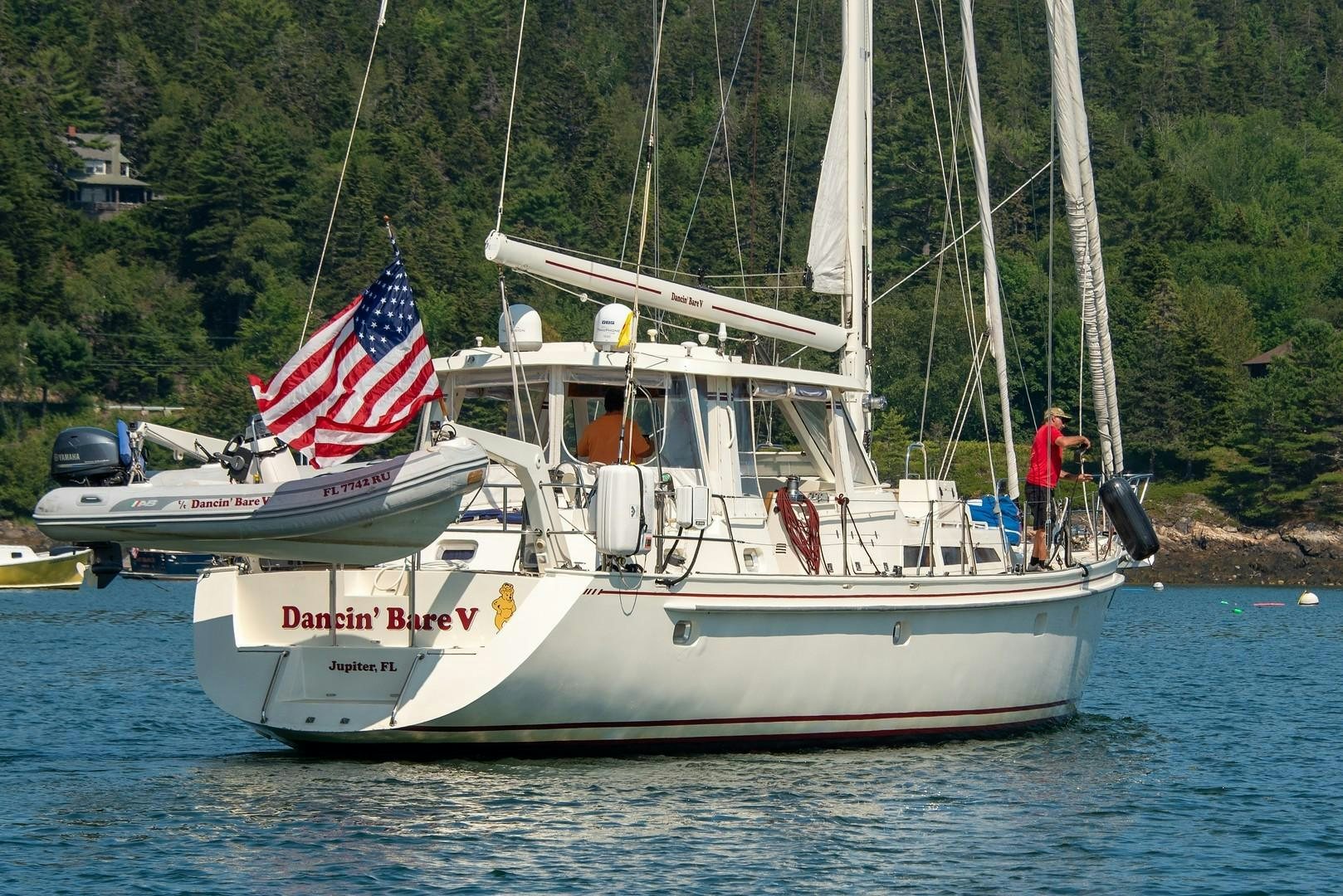 a boat with a flag on it aboard DANCIN BARE V Yacht for Sale