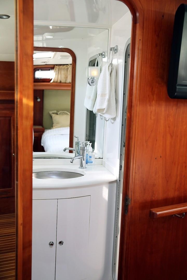 a bathroom with a sink and a mirror aboard DANCIN BARE V Yacht for Sale