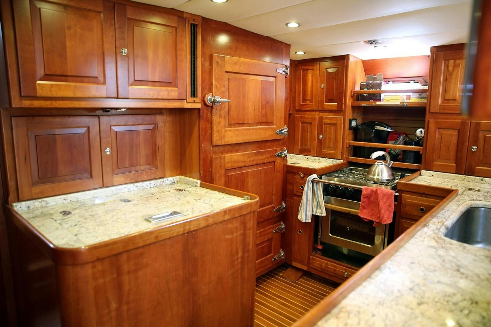 a kitchen with wooden cabinets aboard DANCIN BARE V Yacht for Sale