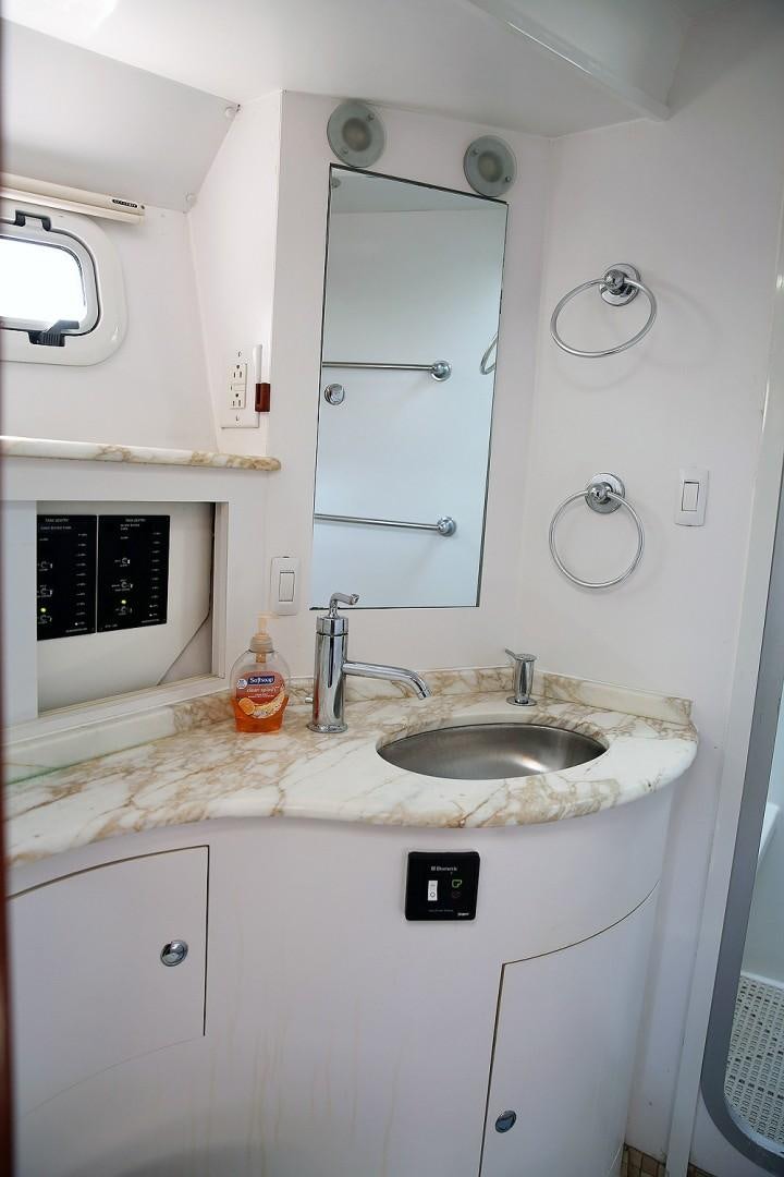 a small white kitchen with a sink and microwave aboard DANCIN BARE V Yacht for Sale