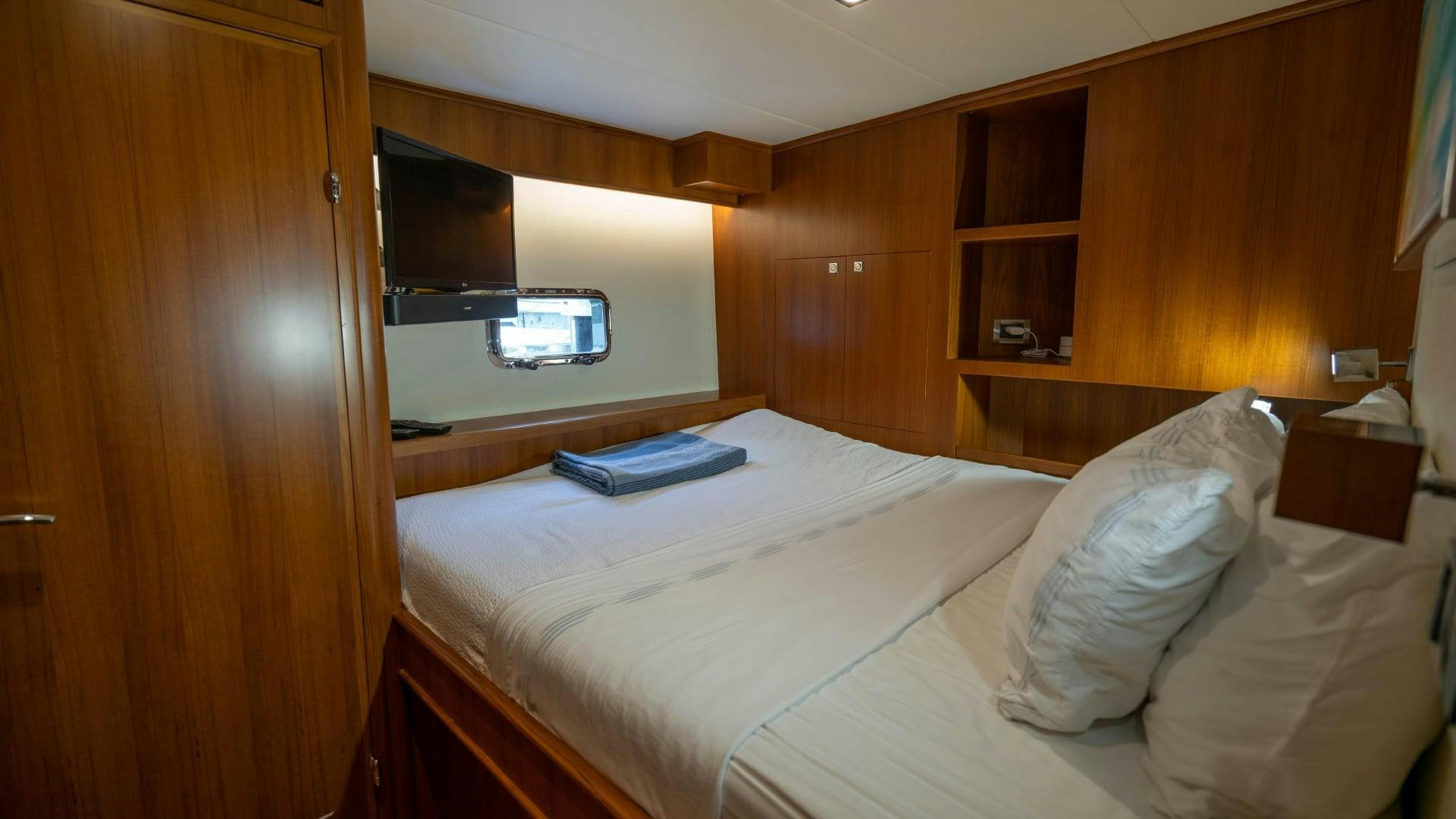 a room with a bed and a television aboard BLUE CHIP Yacht for Sale