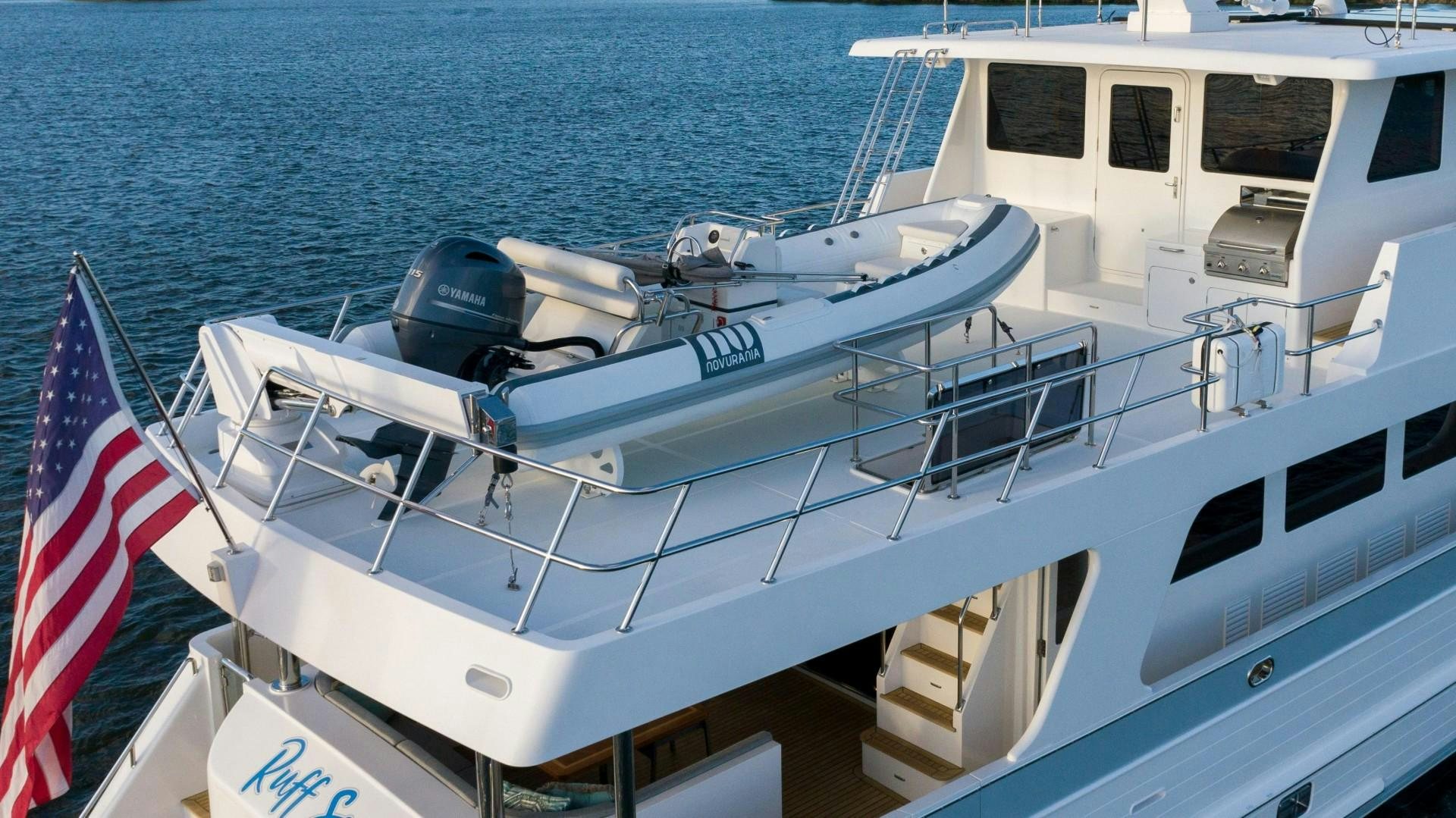 a boat with a flag on the front aboard BLUE CHIP Yacht for Sale