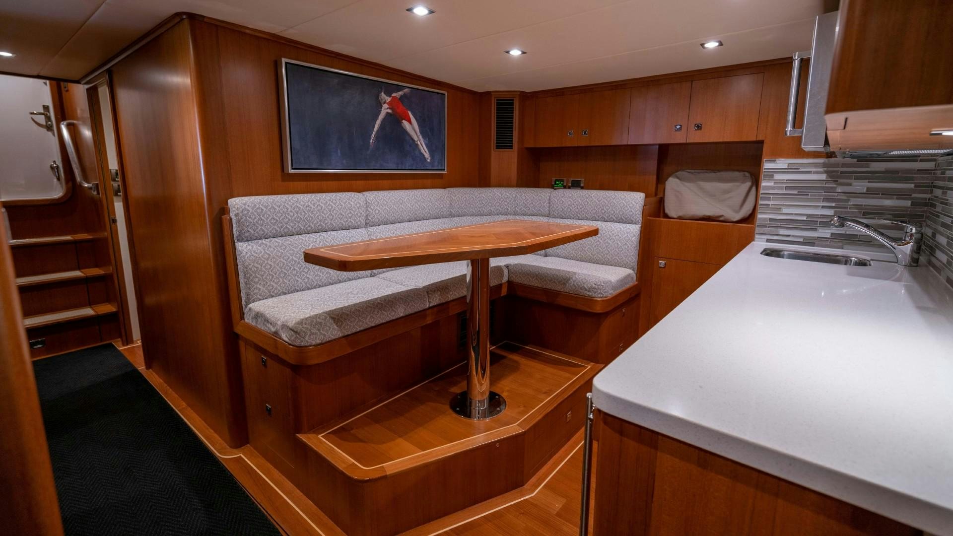a room with a table and a bench aboard BLUE CHIP Yacht for Sale