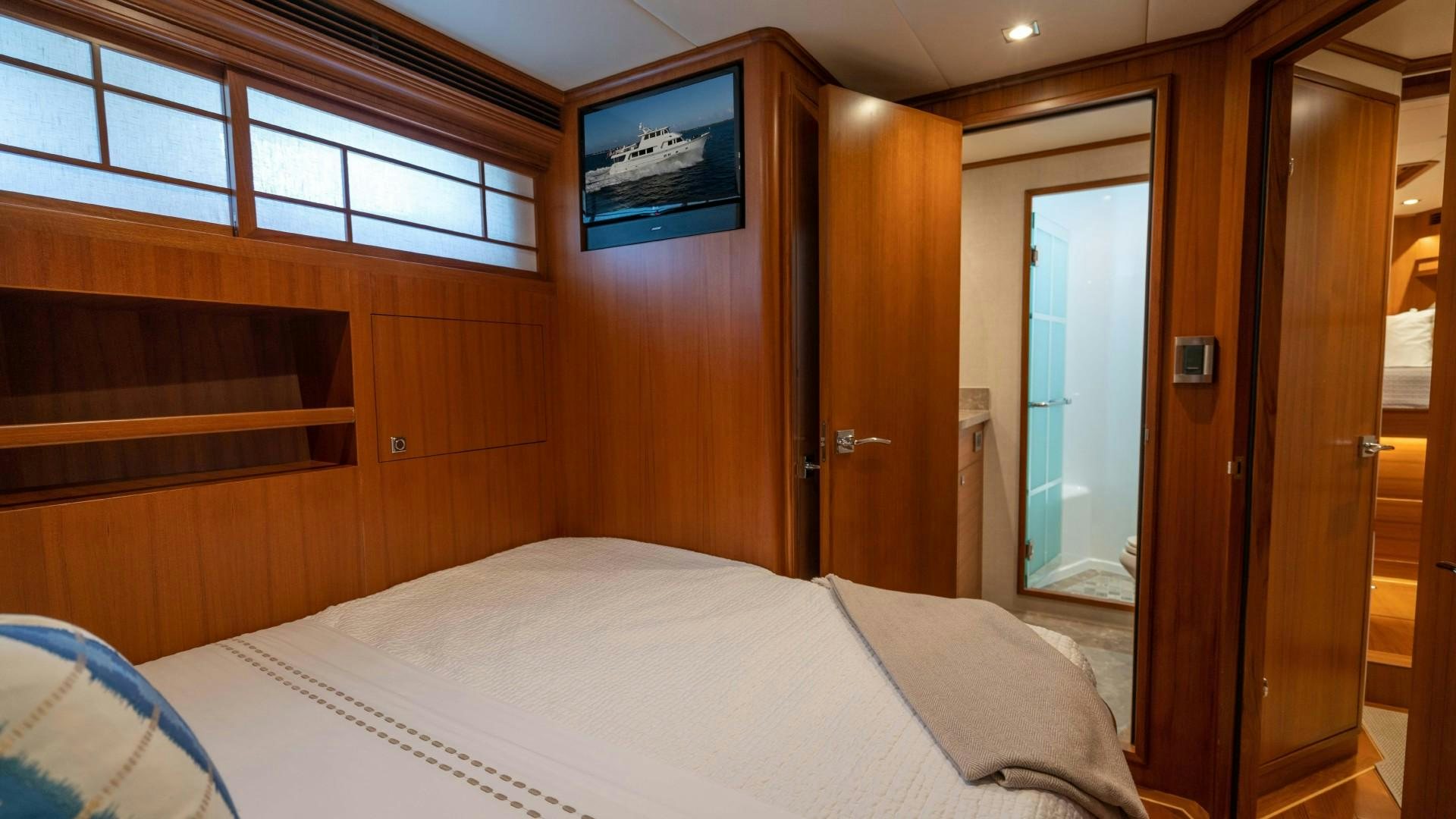 a room with a bed and a television aboard BLUE CHIP Yacht for Sale