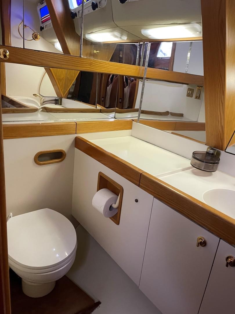 a bathroom with a toilet and a mirror aboard DANCES WITH WOLVES Yacht for Sale