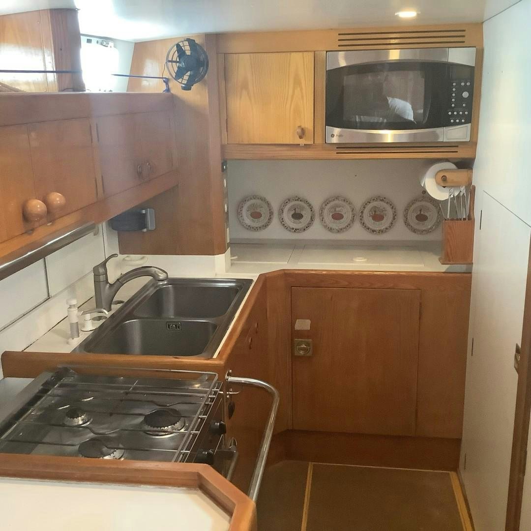 a kitchen with wooden cabinets aboard DANCES WITH WOLVES Yacht for Sale