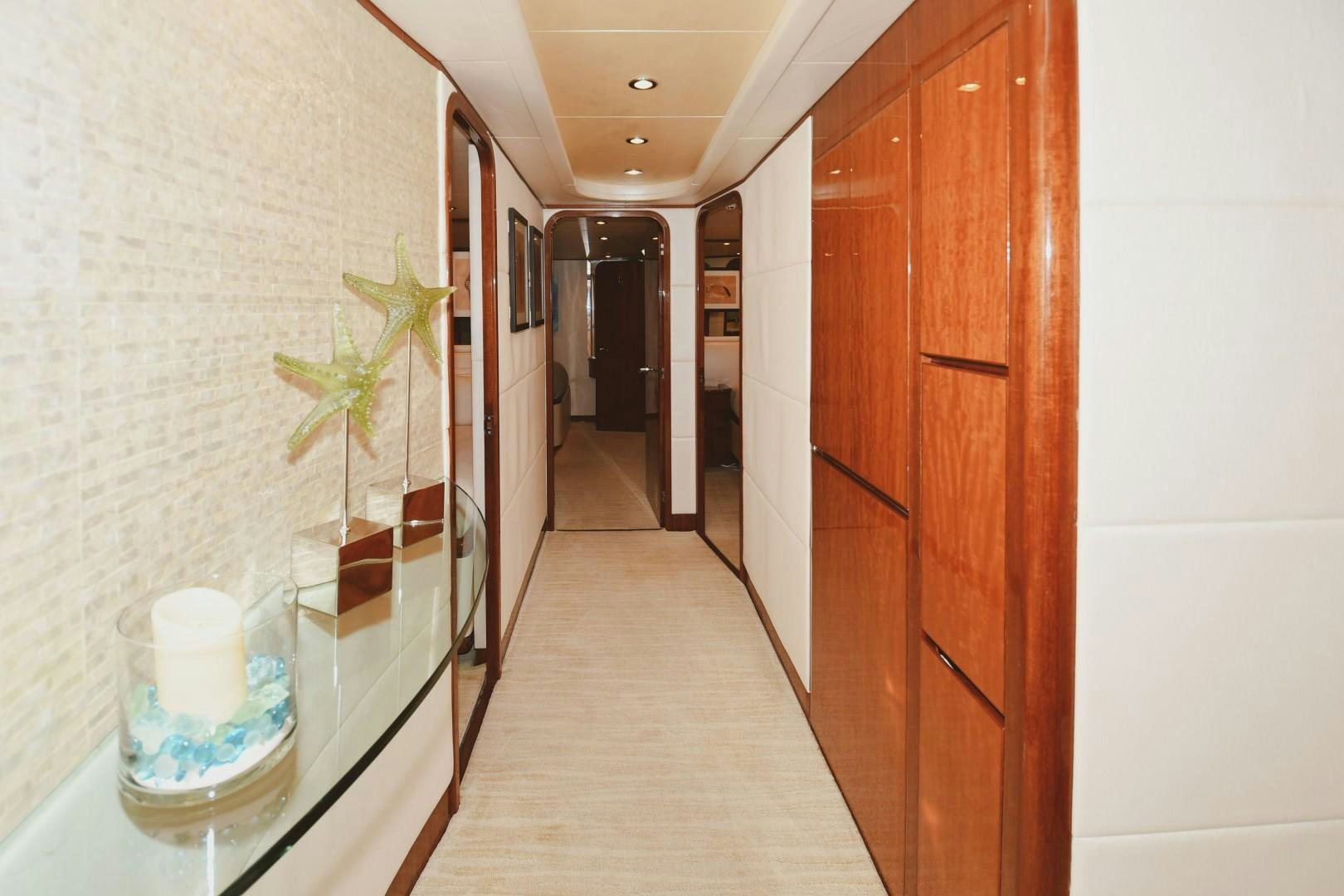 a hallway with a wood door and a plant on the side aboard WARHORSE Yacht for Sale