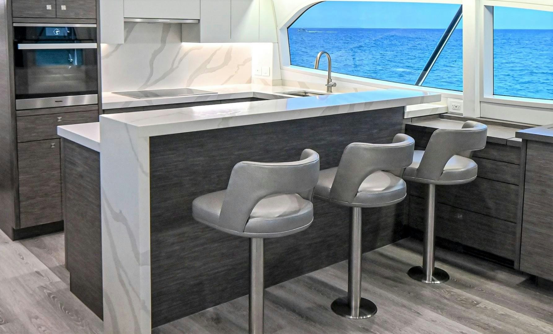 a couple of stools in a kitchen aboard Fish Tank Yacht for Sale