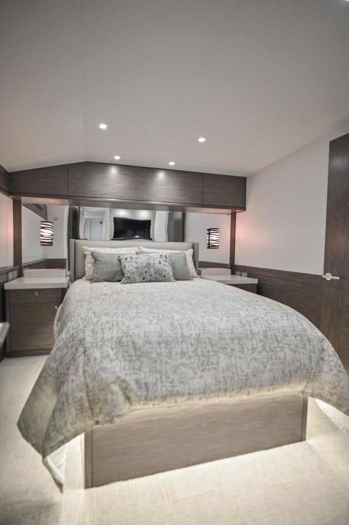 a bed with a white comforter aboard Fish Tank Yacht for Sale