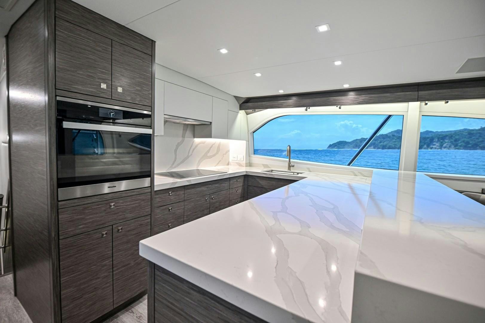 a kitchen with a large window aboard Fish Tank Yacht for Sale
