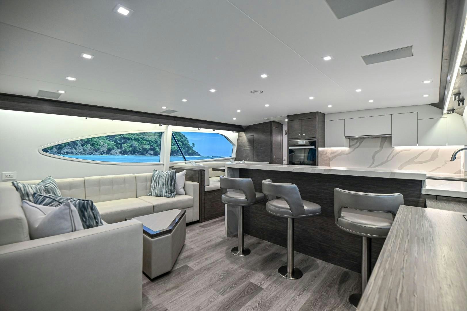 a room with a couch and a table and chairs aboard Fish Tank Yacht for Sale