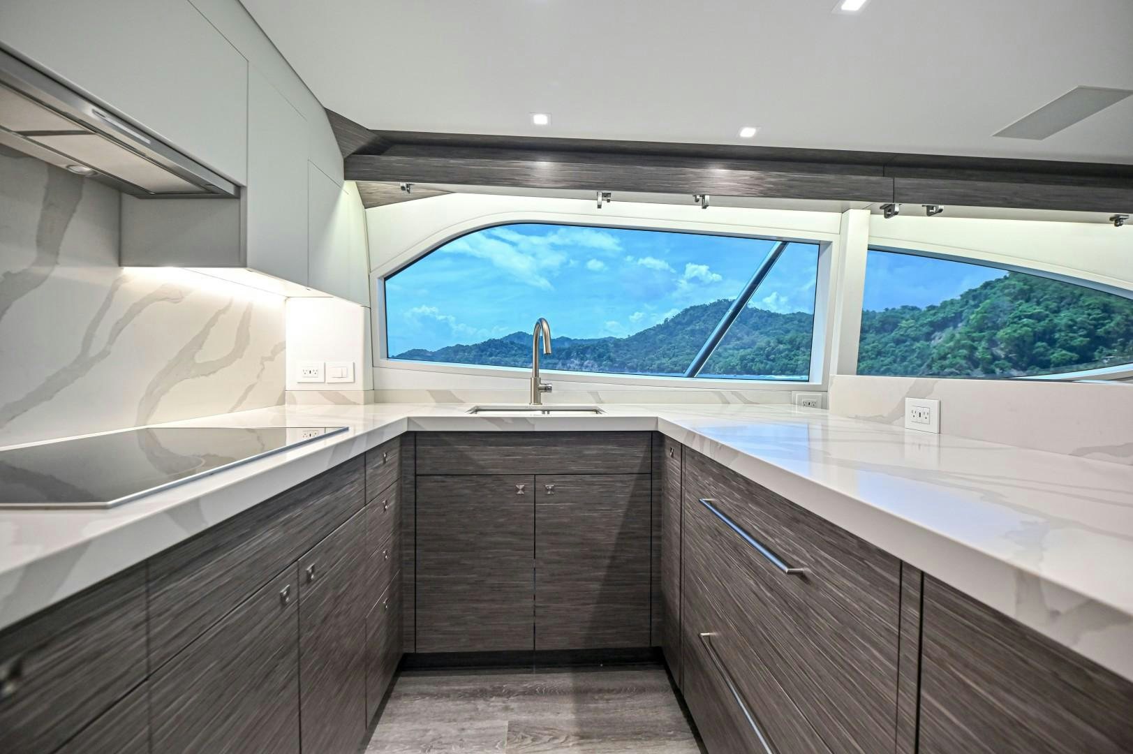 a kitchen with a large window aboard Fish Tank Yacht for Sale