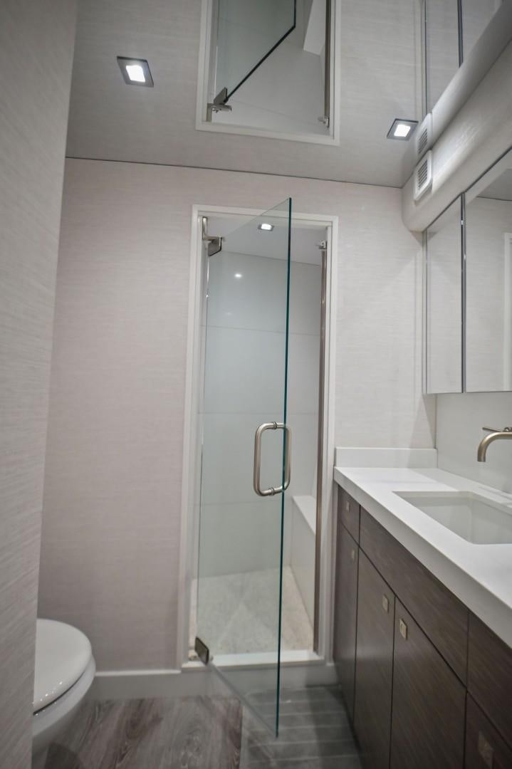 a bathroom with a glass shower door aboard Fish Tank Yacht for Sale