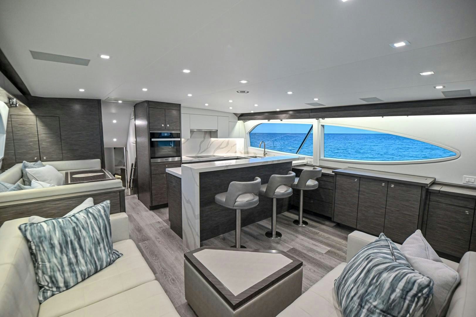 a room with a large window and a table with chairs and a tv aboard Fish Tank Yacht for Sale