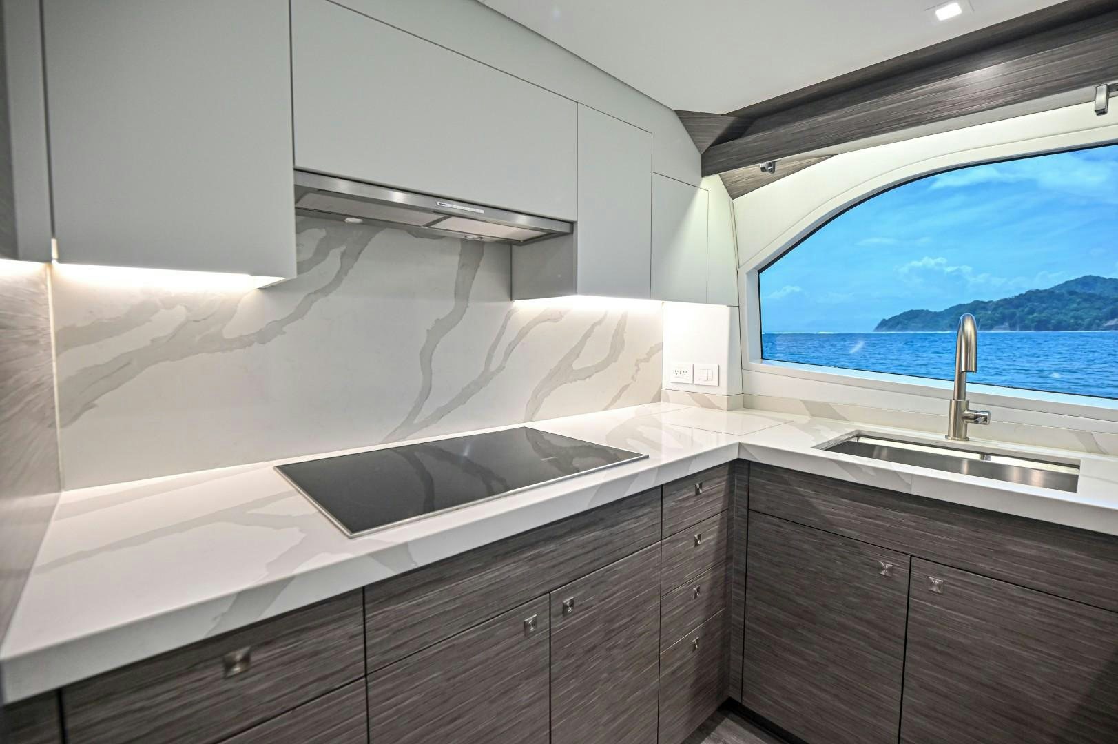a kitchen with a sink and a window aboard Fish Tank Yacht for Sale