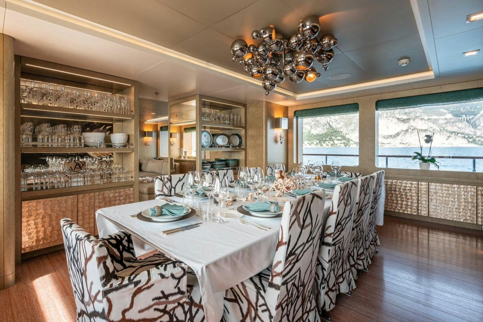 a dining room with a large chandelier aboard LIBERTY Yacht for Sale