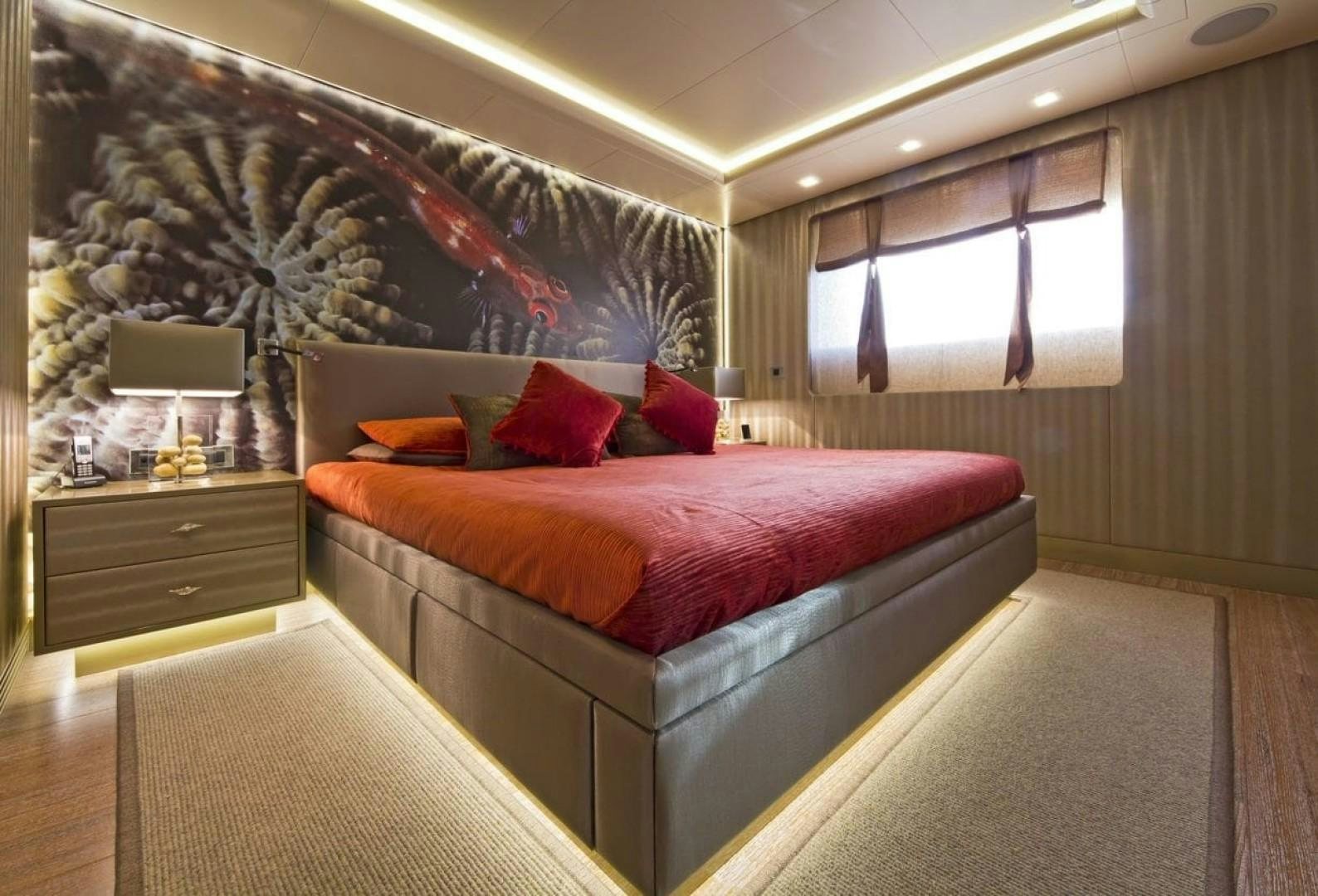 a bedroom with a bed and a desk aboard LIBERTY Yacht for Sale