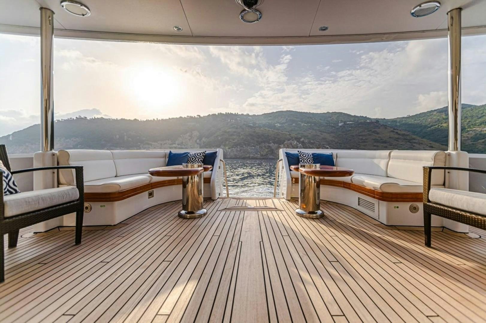 a deck with a view of the ocean and mountains aboard TASIA Yacht for Sale