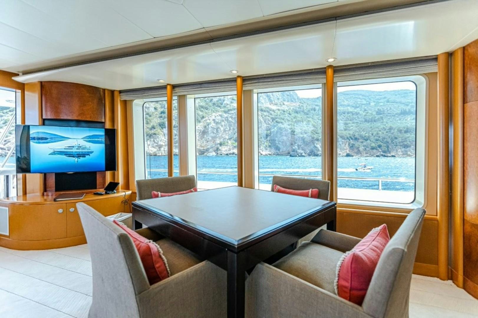 a living room with a table and tv aboard TASIA Yacht for Sale
