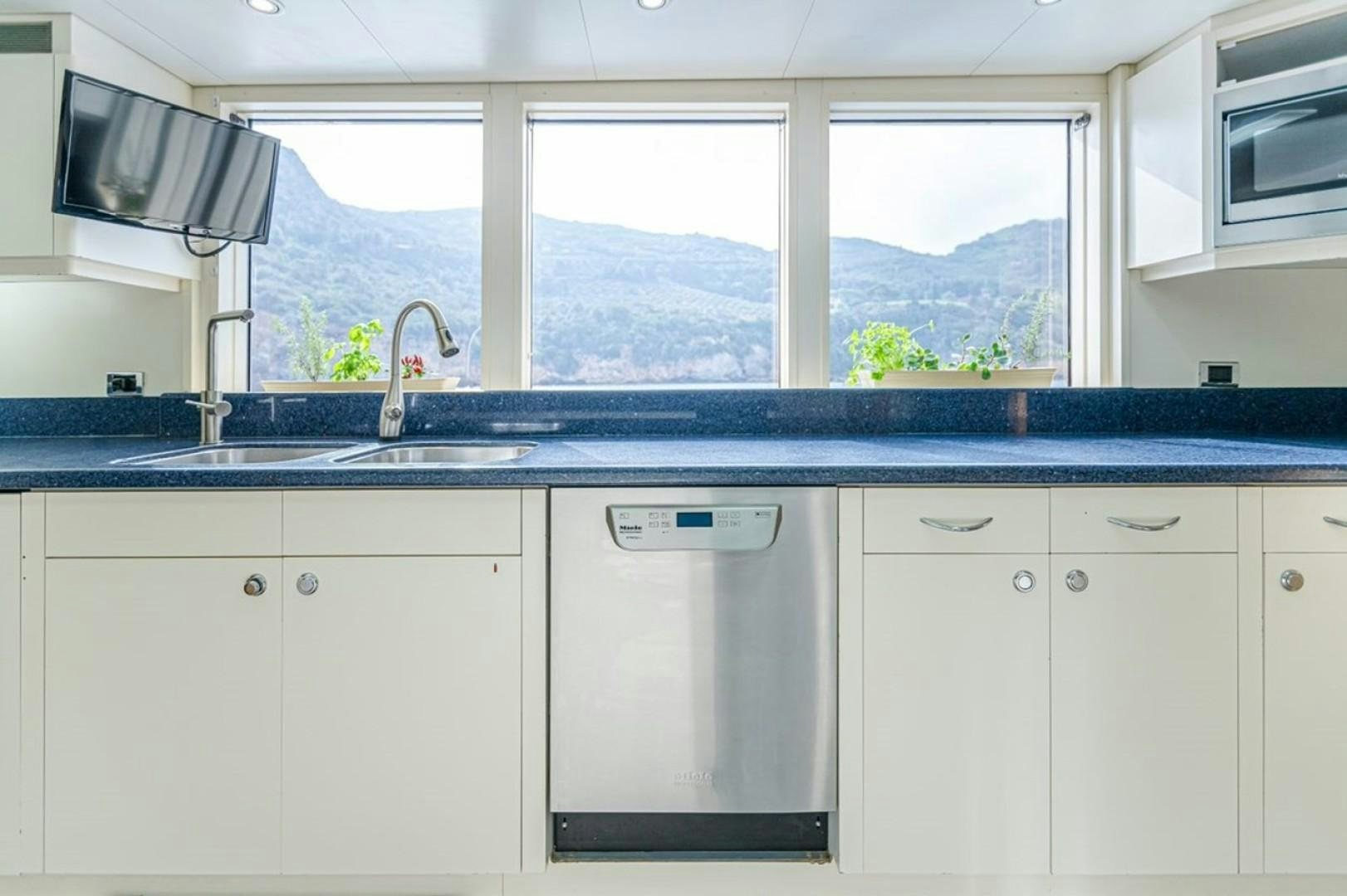 a kitchen with white cabinets aboard TASIA Yacht for Sale