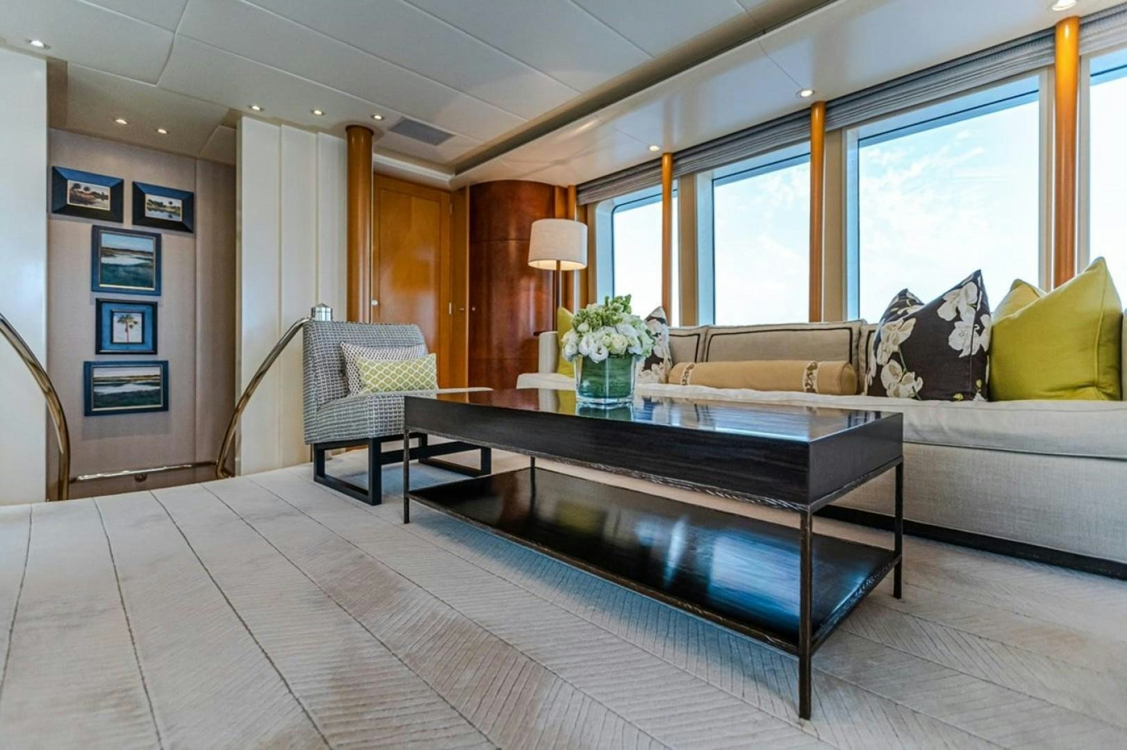 a living room with a large coffee table and a large window aboard TASIA Yacht for Sale