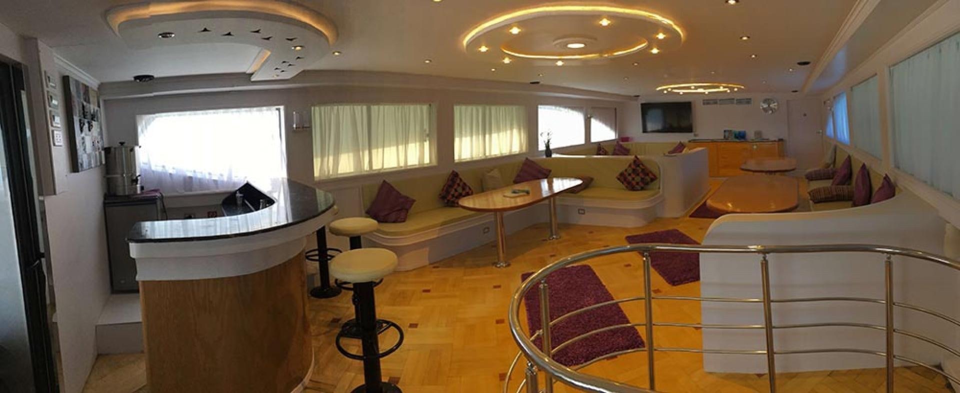 a room with a couch and a table and a television aboard SIM SIM Yacht for Sale