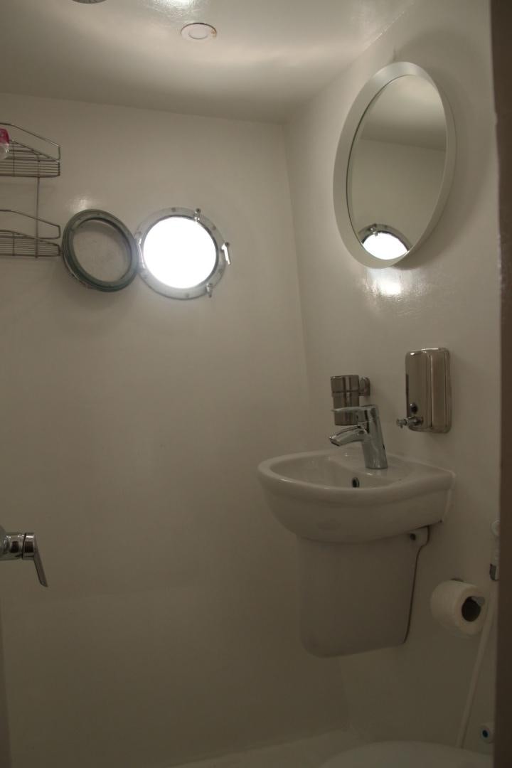a bathroom with a round mirror aboard SIM SIM Yacht for Sale