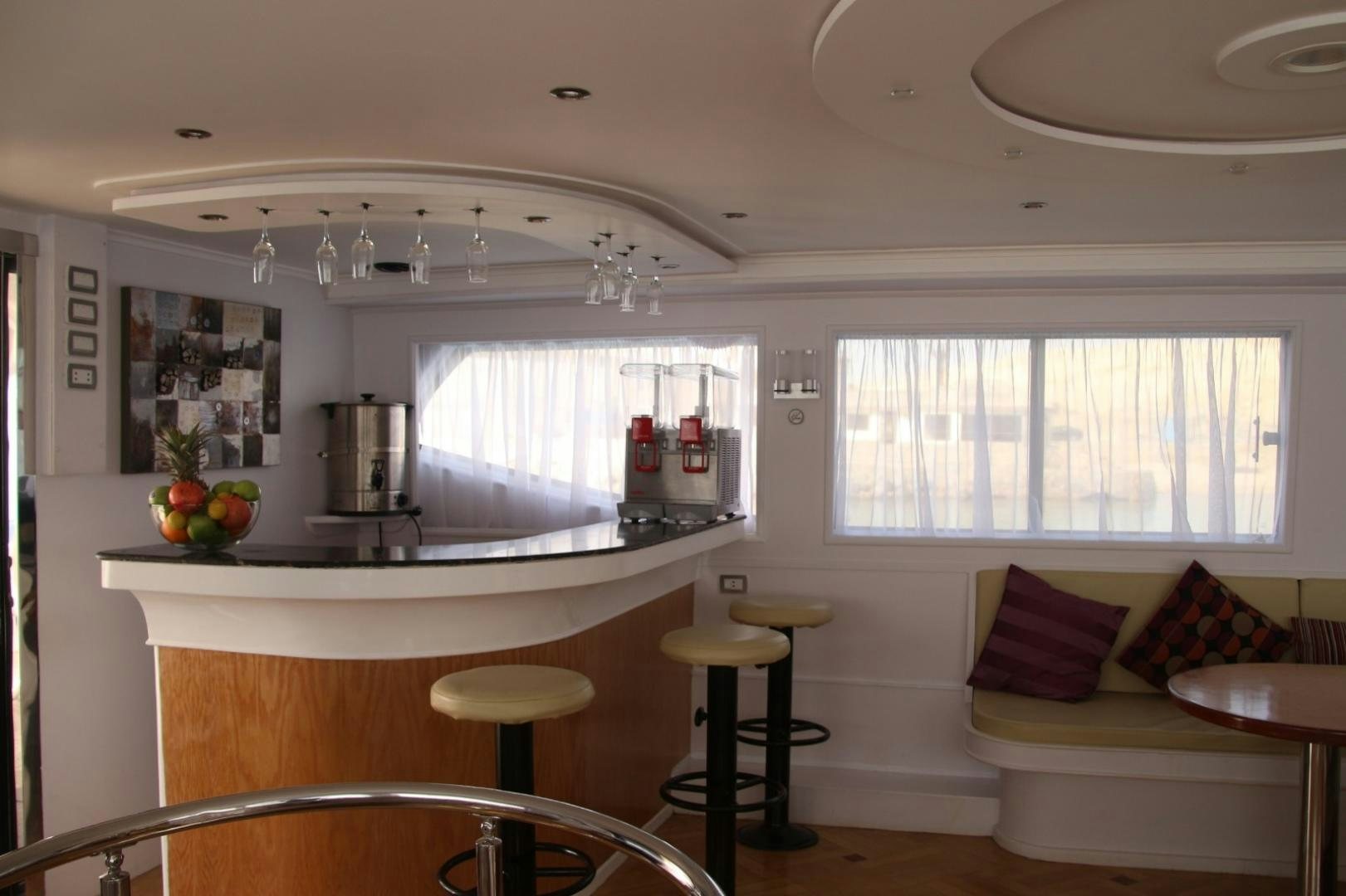 a kitchen with a table and stools aboard SIM SIM Yacht for Sale
