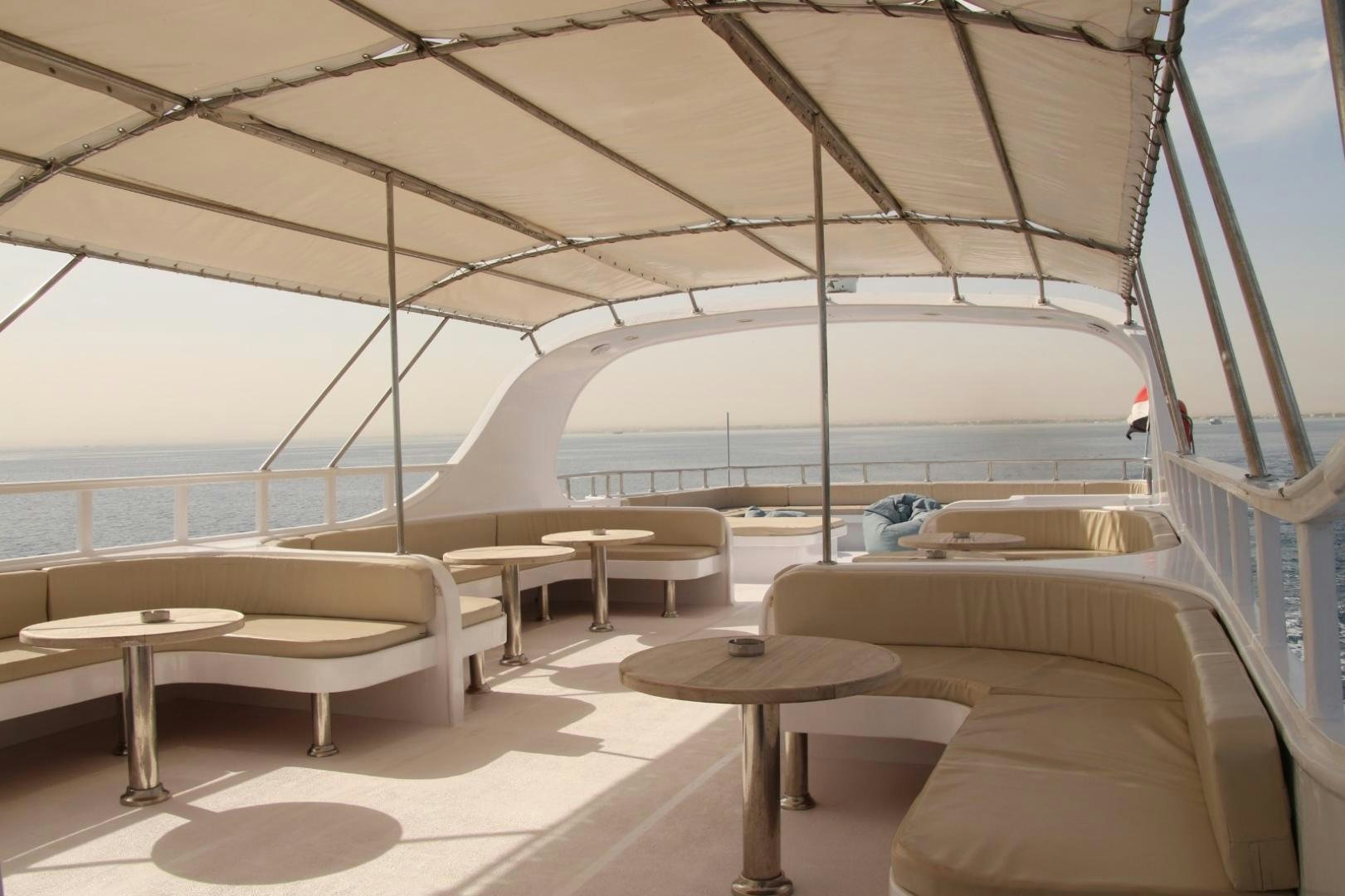 a room with tables and chairs aboard SIM SIM Yacht for Sale