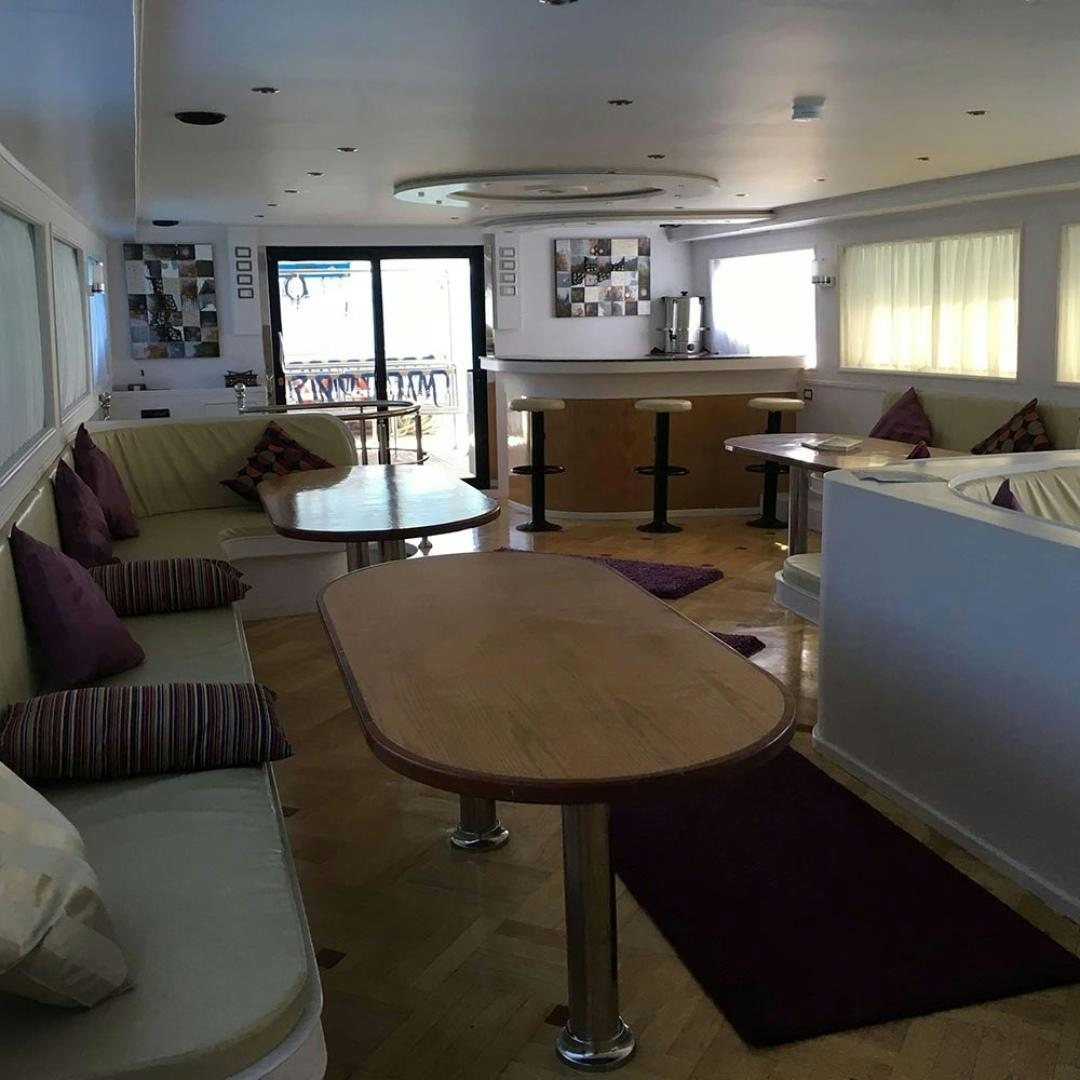 a living room with a table and chairs aboard SIM SIM Yacht for Sale