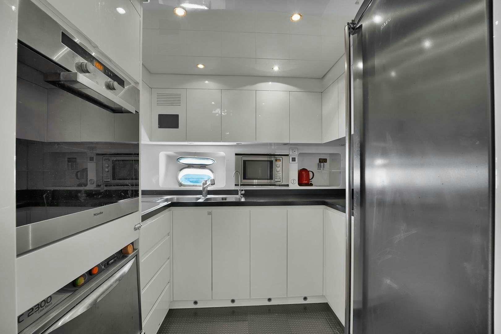 a kitchen with white cabinets aboard CHURRI Yacht for Sale